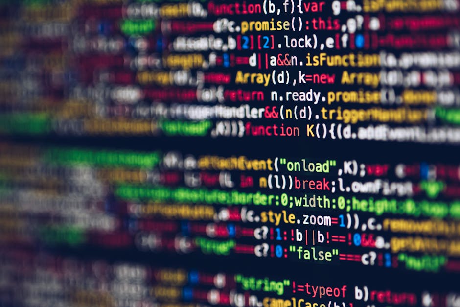 A close-up image of a computer screen displaying colorful code, with lines of programming language including functions, variables, and syntax highlighted in red, green, blue, yellow, and white. The te